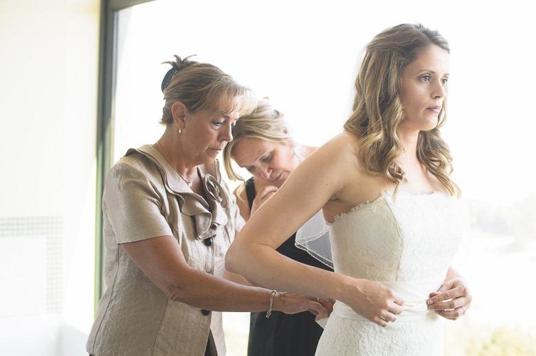 Kelowna wedding, bride puts on dress with mom and sister, by Electrify Photography, Kelowna BC and Nelson BC Wedding Photographer