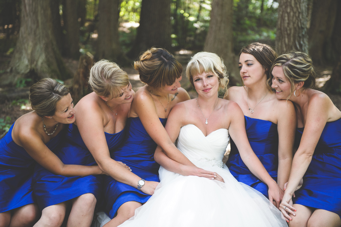 Bridesmaids in blue gaze at their beloved friend at Kokanee Creek Park, by Nelson BC Kootenay wedding photographer Emilee Zaitsoff of Electrify Photograph