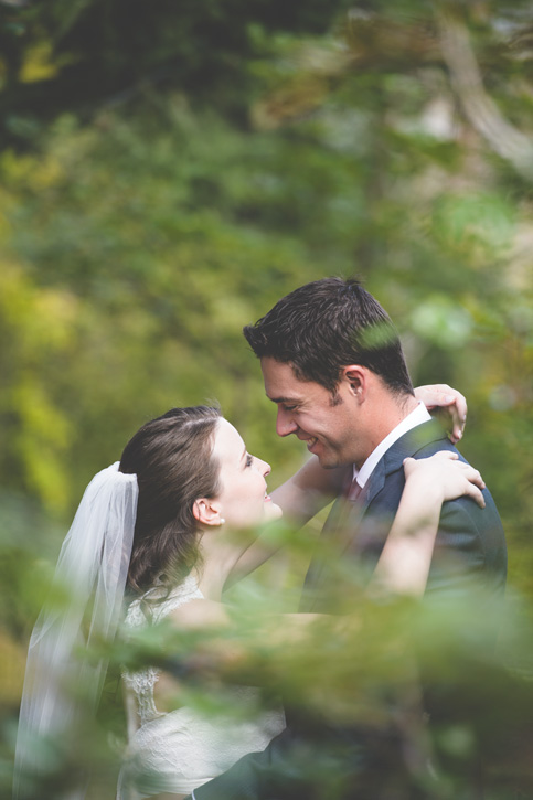 Bride and groom have a candid moment in the woods near Kelowna, BC, Okanagan by Nelson BC Kootenay wedding photographer Emilee Zaitsoff of Electrify Photography