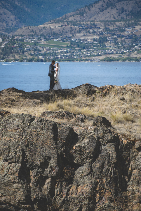 Bride and groom cliffside with gorgeous vineyard views near Kelowna, BC, Okanagan by Nelson BC Kootenay wedding photographer Emilee Zaitsoff of Electrify Photography