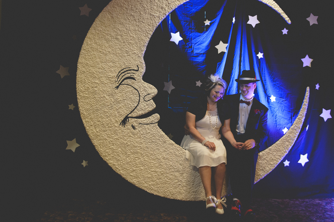 Bride and groom in handmade moon photobooth prop, 1920s theme at Prestige Resort, by Nelson BC Kootenay wedding photographer Emilee Zaitsoff of Electrify Photograph