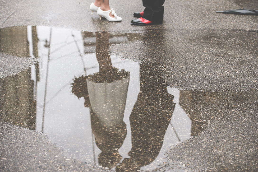 A kiss reflected in a puddle in the alley, by Nelson BC Kootenay wedding photographer Emilee Zaitsoff of Electrify Photograph