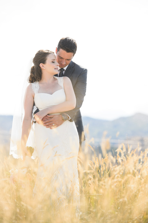 Bride and groom in afternoon sunny field near Kelowna, BC, Okanagan by Nelson BC Kootenay wedding photographer Emilee Zaitsoff of Electrify Photography